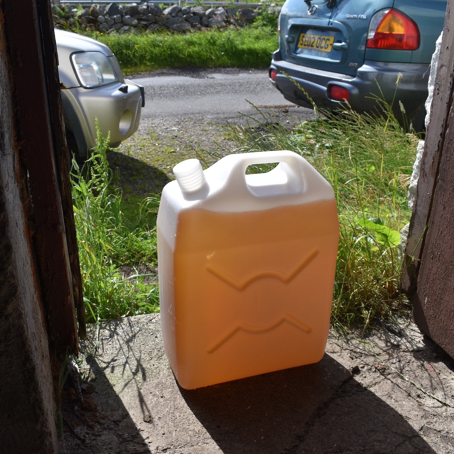 Jerrycan of discoloured raw water at a farm steading in the Hebrides